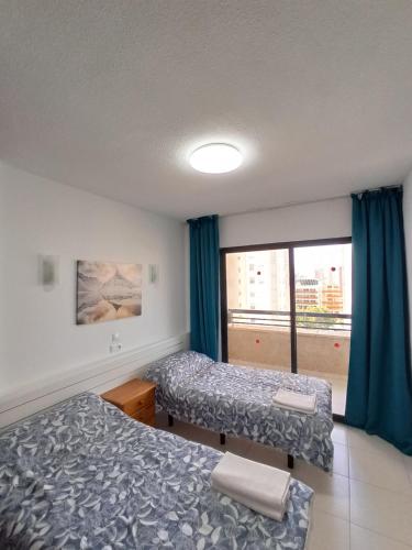 a hotel room with two beds and a window at Lux Benidorm in Benidorm