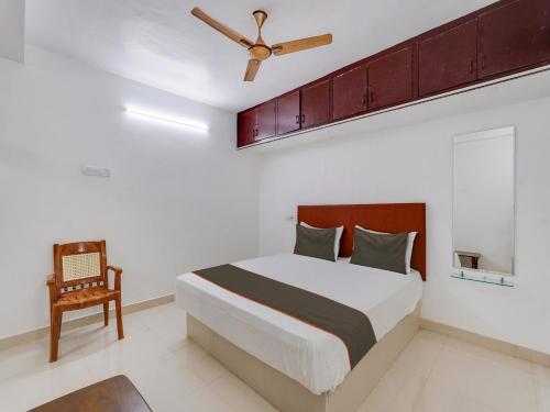 a bedroom with a bed and a ceiling fan at Collection O Anu Villas in Chennai