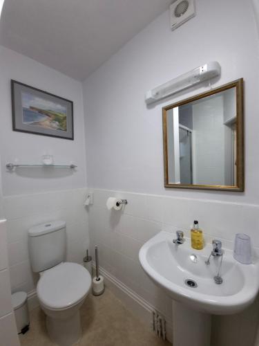 een witte badkamer met een toilet en een wastafel bij The Cavendish in Scarborough