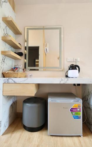 a bathroom with a counter with a mirror and a trash can at Lake Hill Resort Kanchanaburi in Tha Kradan