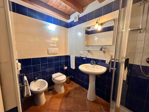 Baño de azulejos azules con aseo y lavamanos en Al Palmento Cruillas, en Siracusa