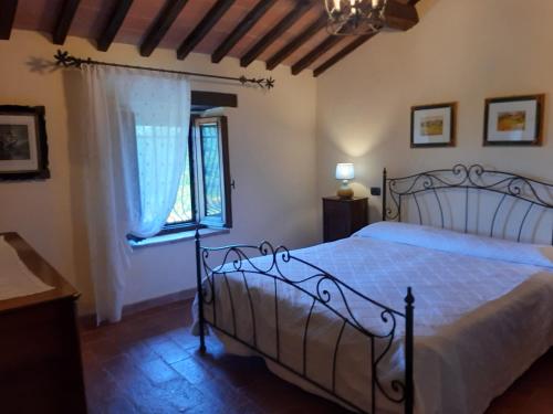 a bedroom with a bed and a window at Casale delle Due Fonti in San Venanzo