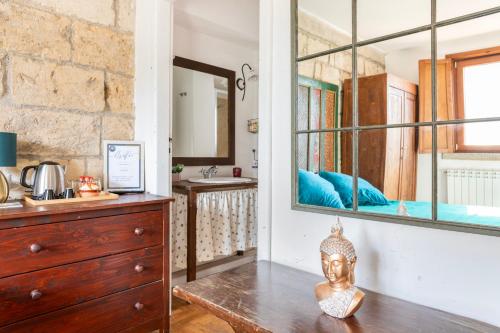 a bathroom with a mirror and a statue on a wooden floor at Bari LandLord 71 - Central Rooms in Bari