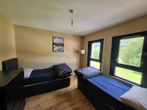 Habitación con 2 camas y ventana en Kinlochleven Holiday Home, en Kinlochleven