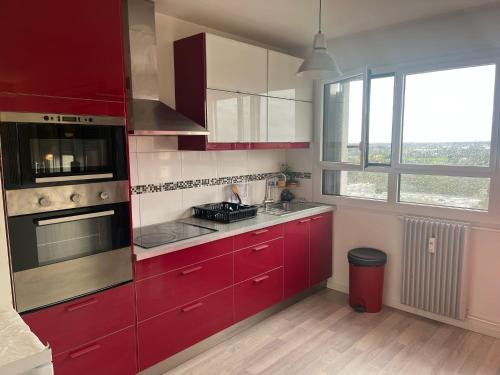 uma cozinha vermelha com armários vermelhos e uma janela em Chambres d'Hôtes Kennedy, Villejean em Rennes
