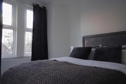 um quarto com uma cama e uma janela em Milton Place em Londres