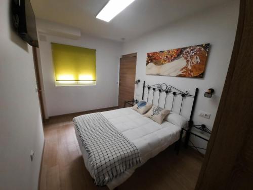 a bedroom with a bed and a painting on the wall at Casa María in Málaga