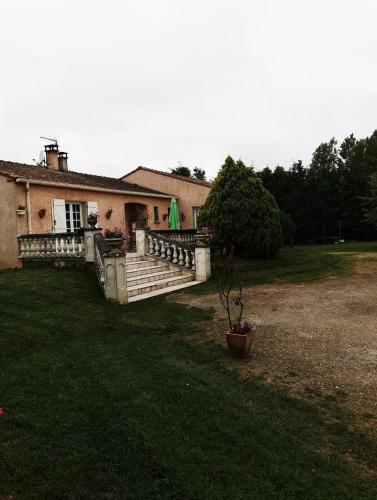 une maison avec une grande terrasse couverte et une cour dans l'établissement jean guy andrieu, à Labruguière