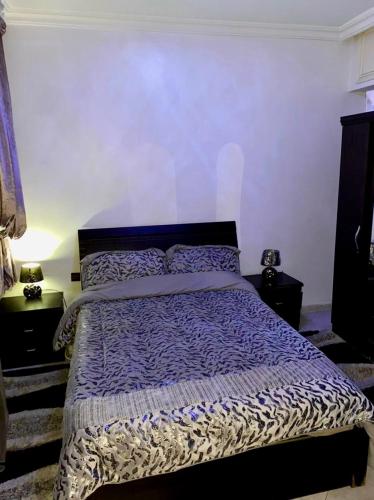 - une chambre avec un lit et une couette bleue et blanche dans l'établissement Appartement au cœur du ville, à Tanger