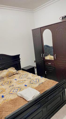 - une chambre avec un lit, une commode et un miroir dans l'établissement Appartement au cœur du ville, à Tanger