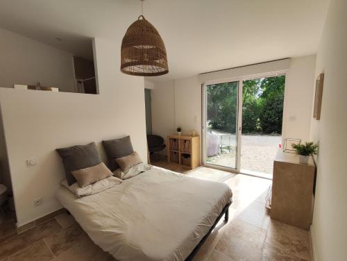 une chambre avec un lit et une grande fenêtre dans l'établissement Villa avec piscine proche centre ville Nîmes, à Nîmes