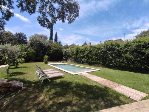 - une piscine dans une cour avec un banc dans l'établissement Villa avec piscine proche centre ville Nîmes, à Nîmes