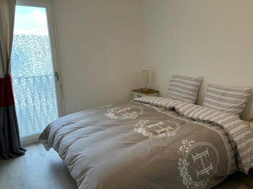 uma cama num quarto com uma grande janela em DUPLEX Luxury-Appart - DYSNEY LAND PARIS em Bussy-Saint-Georges