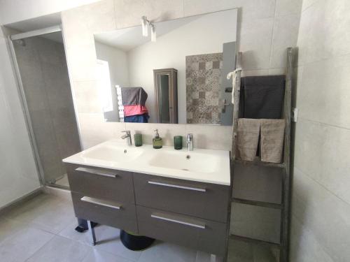 une salle de bain avec un lavabo et un miroir dans l'établissement Villa avec piscine proche centre ville Nîmes, à Nîmes