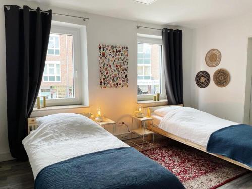 2 camas en un dormitorio con 2 ventanas en Ferienwohnung Delta en Heinsberg