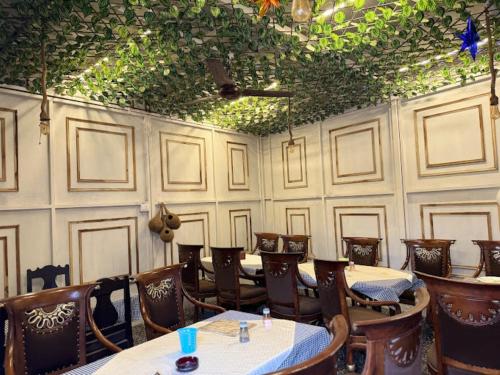 a dining room with tables and chairs and ceilings at Hotel Kamal Agra in Agra