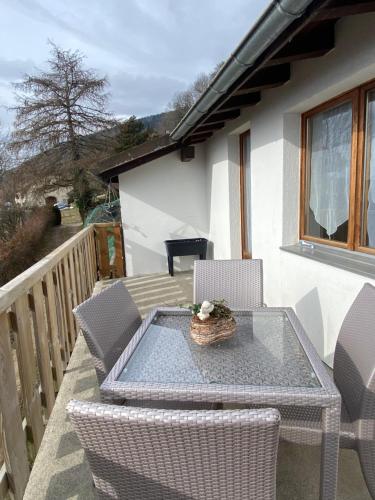 een patio met een tafel en stoelen op een balkon bij Tévenon Vue Panoramique Alpes-Lac in Grandevent