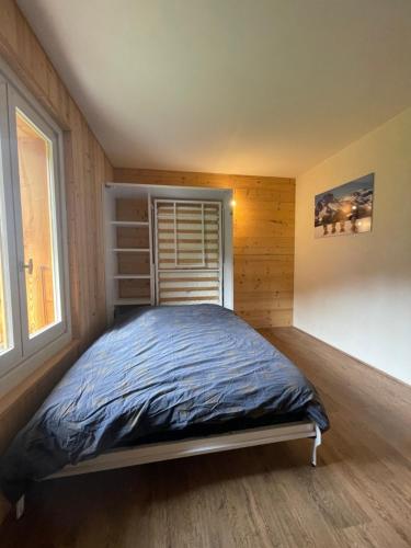 une chambre avec un lit dans une pièce avec une fenêtre dans l'établissement Hyper centres, à La Clusaz