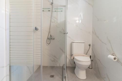 a bathroom with a toilet and a glass shower at Seashell by halu! in Nea Fokea