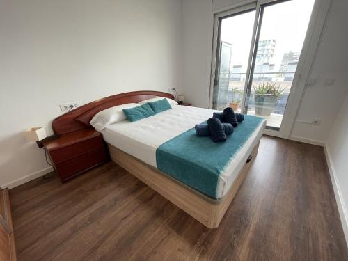 um quarto com uma cama e uma grande janela em Alucinante ático frente al mar em Mataró