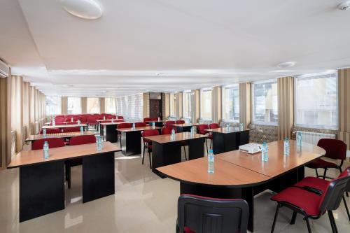 a restaurant with wooden tables and red chairs at Balneocomplex Kamena in Velingrad