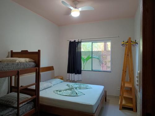 a bedroom with two bunk beds and a window at Casa temporada in Arraial do Cabo