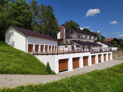 a white building with a balcony on top of it at Apratmán Julie – Bavorská Ruda in Bayerisch Eisenstein