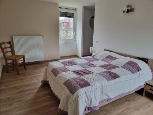 une chambre avec un lit, une chaise et une fenêtre dans l'établissement Gîte Sarazac, à Mayac