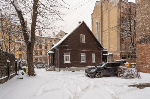 a car parked in front of a house in the snow at Brīvdienu māja pašā Rīgas sirdī in Riga