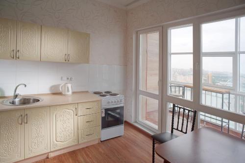 a kitchen with a sink and a stove top oven at Grand Alatau in Astana