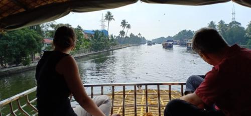 três pessoas sentadas num barco a olhar para um rio em Beach Paradise Day Cruise Houseboat - VACCINATED STAFF em Alappuzha