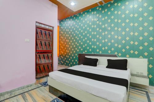 1 dormitorio con cama y papel pintado azul y amarillo en OYO C.M Paradise, en Lucknow
