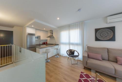 a living room with a couch and a kitchen at Cituspace Arturo Soria in Madrid