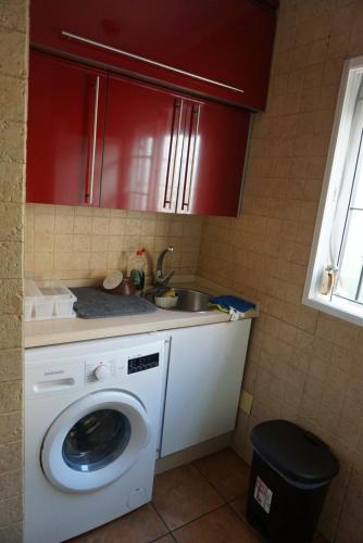 a kitchen with a washing machine and a sink at Apartamento en Huelva. in Huelva
