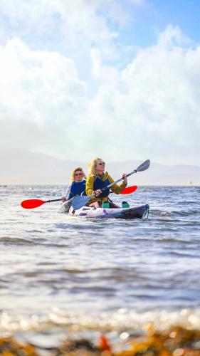 a man and a woman kayaking on the water at Parknasilla Resort & Spa in Sneem