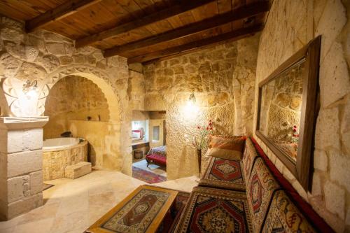 a large room with a tub in a stone building at Antique House Cappadocia in Nevsehir