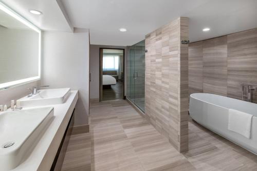 een badkamer met 2 wastafels en een bad bij Madison Marriott West in Middleton