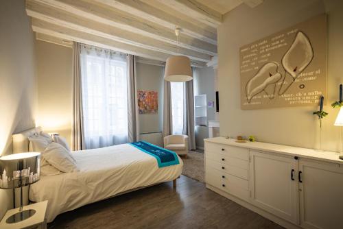1 dormitorio con 1 cama, vestidor y ventana en Gîte Jeanne D'Arc en Loches