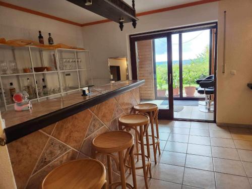 - un bar avec tabourets en bois dans la cuisine avec vue dans l'établissement Ferienwohnung Brenda, à Schillingsfürst