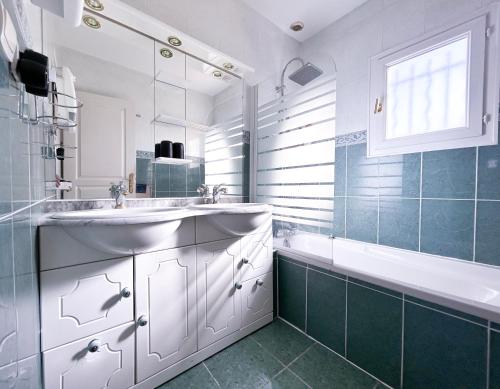 La salle de bains blanche est pourvue d'un lavabo, d'une baignoire et d'une chambre. dans l'établissement Villa Piscine et Jardin Ensoleillé, à Saint-André-de-Sangonis