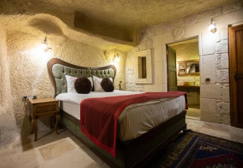 a bedroom with a large bed in a stone room at Antique House Cappadocia in Nevsehir