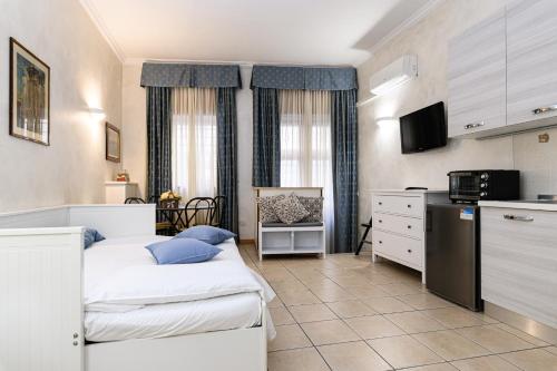 ローマにあるApartment Julia Guesthouseのベッド2台とキッチンが備わる小さな客室です。