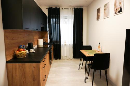 a kitchen with a counter and a table with chairs at Nowoczesny Apartament Prudnik in Prudnik