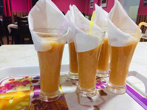 a group of four glasses of beer on a tray at Heritage B.R Hotel Suites and Restaurant in Chittagong