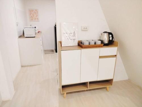 ハジャイにあるGarmin House 8PAX 3BR in Hatyai Townの白いキャビネットと冷蔵庫のあるキッチン