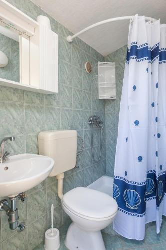a bathroom with a toilet sink and a shower curtain at Holiday home Sweet Shelter with jacuzzi in Živogošće