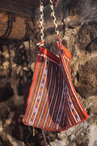 an orange purse hanging on a stone wall at Holiday home Sweet Shelter with jacuzzi in Živogošće