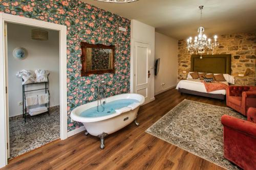 a bathroom with a bath tub and a bedroom at Ecocasa Lema II in Muxia