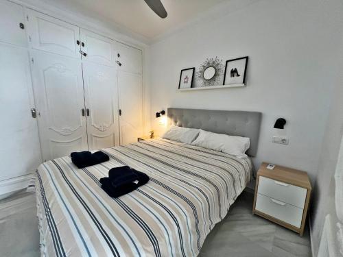 Un dormitorio con una cama con una bolsa negra. en Coqueto ático de playa, en Fuengirola