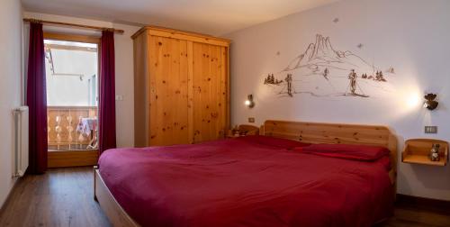 1 dormitorio con 1 cama grande con manta roja en Casa Davarda, en Vigo di Fassa